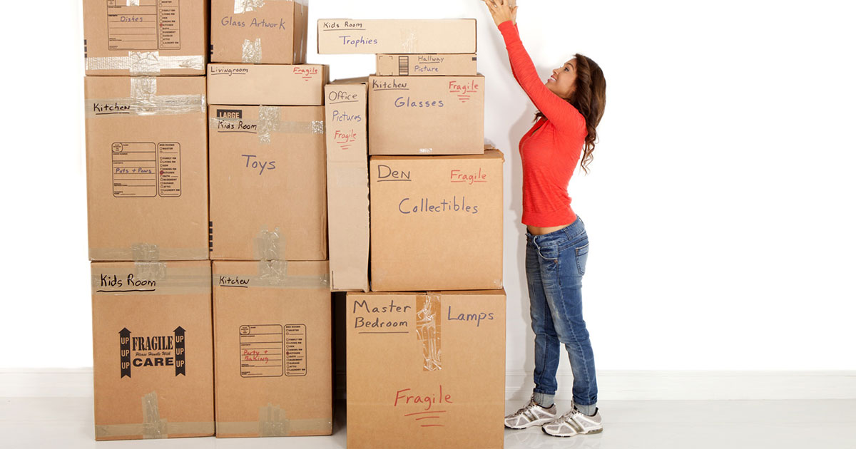 Woman reaching up to stack a box
