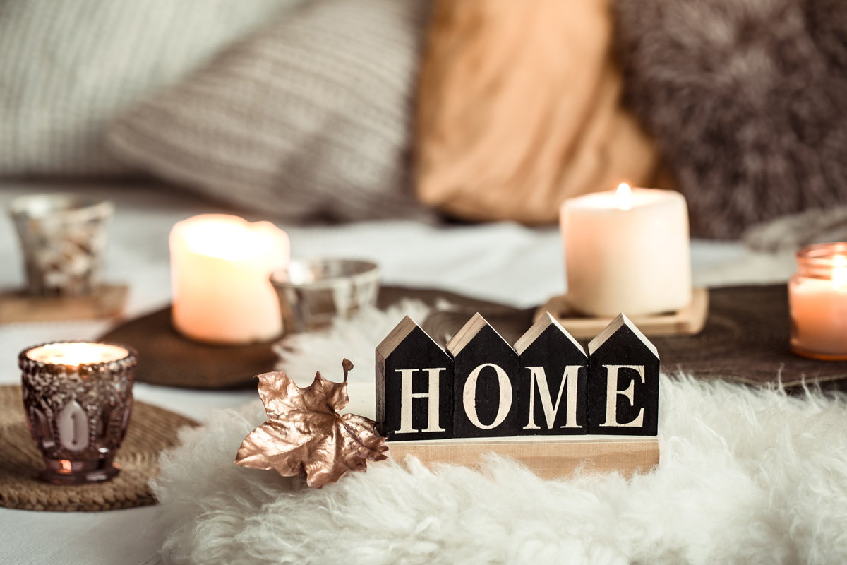 home decor sign surrounded by pillows and candles.